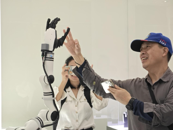 參觀者與具身智能機(jī)器人手臂進(jìn)行互動(dòng)。人民網(wǎng)記者 焦磊攝